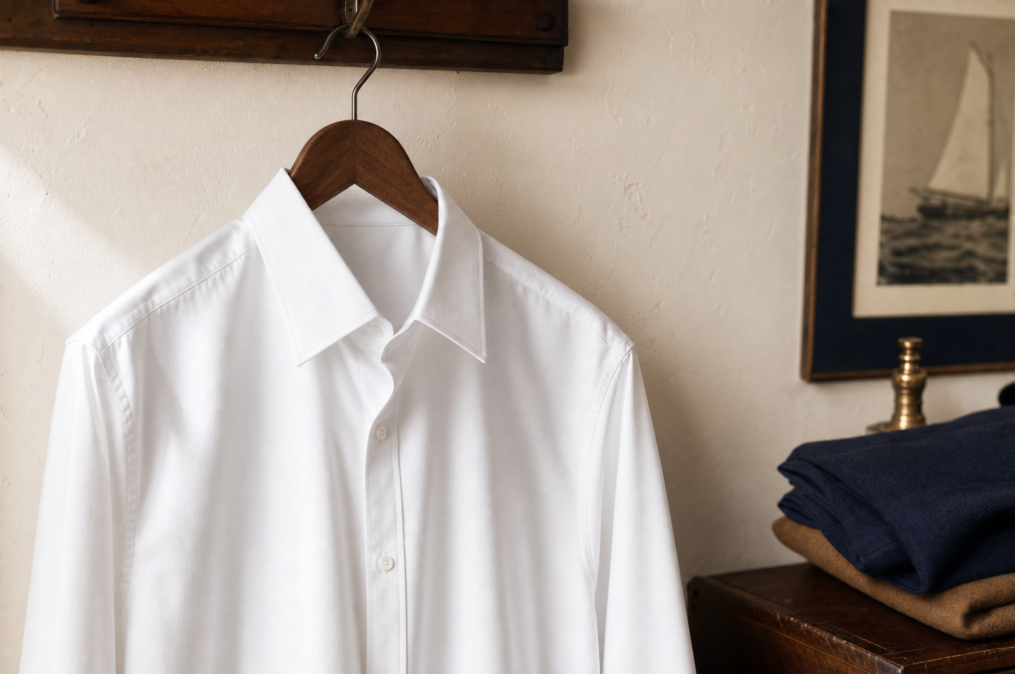 A white Oxford dress shirt on a wooden hanger